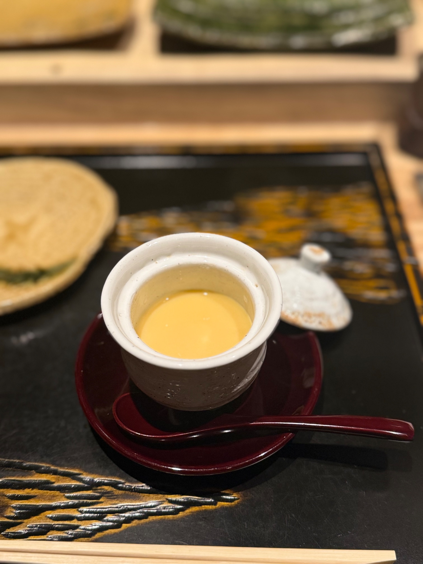 炭火で焼かれる鶏と器が並ぶカウンター
